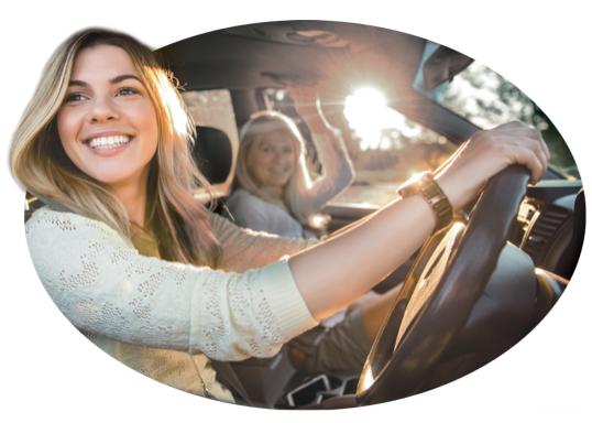 A smiling woman enjoys her safe-driving discount